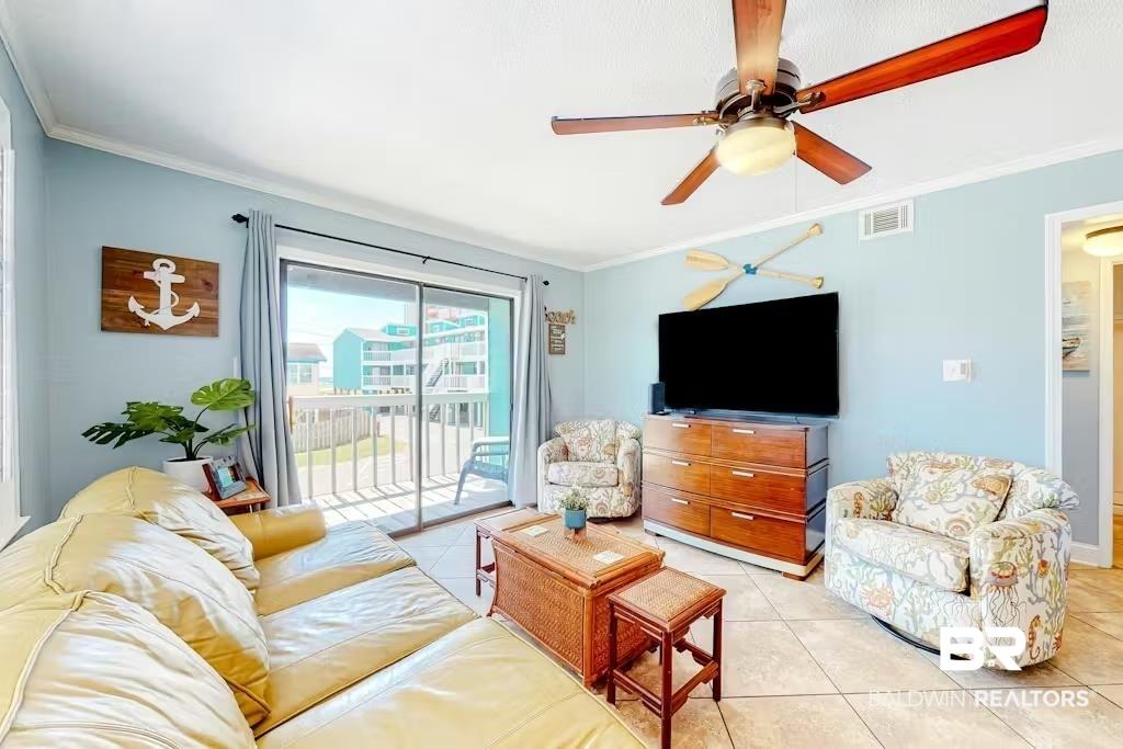 Image 2: Living area with ornamental molding, light tile patterned floors, and ceiling fan