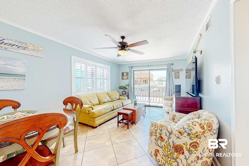 Image 3: Tiled living area with a textured ceiling, ceiling fan, and crown molding