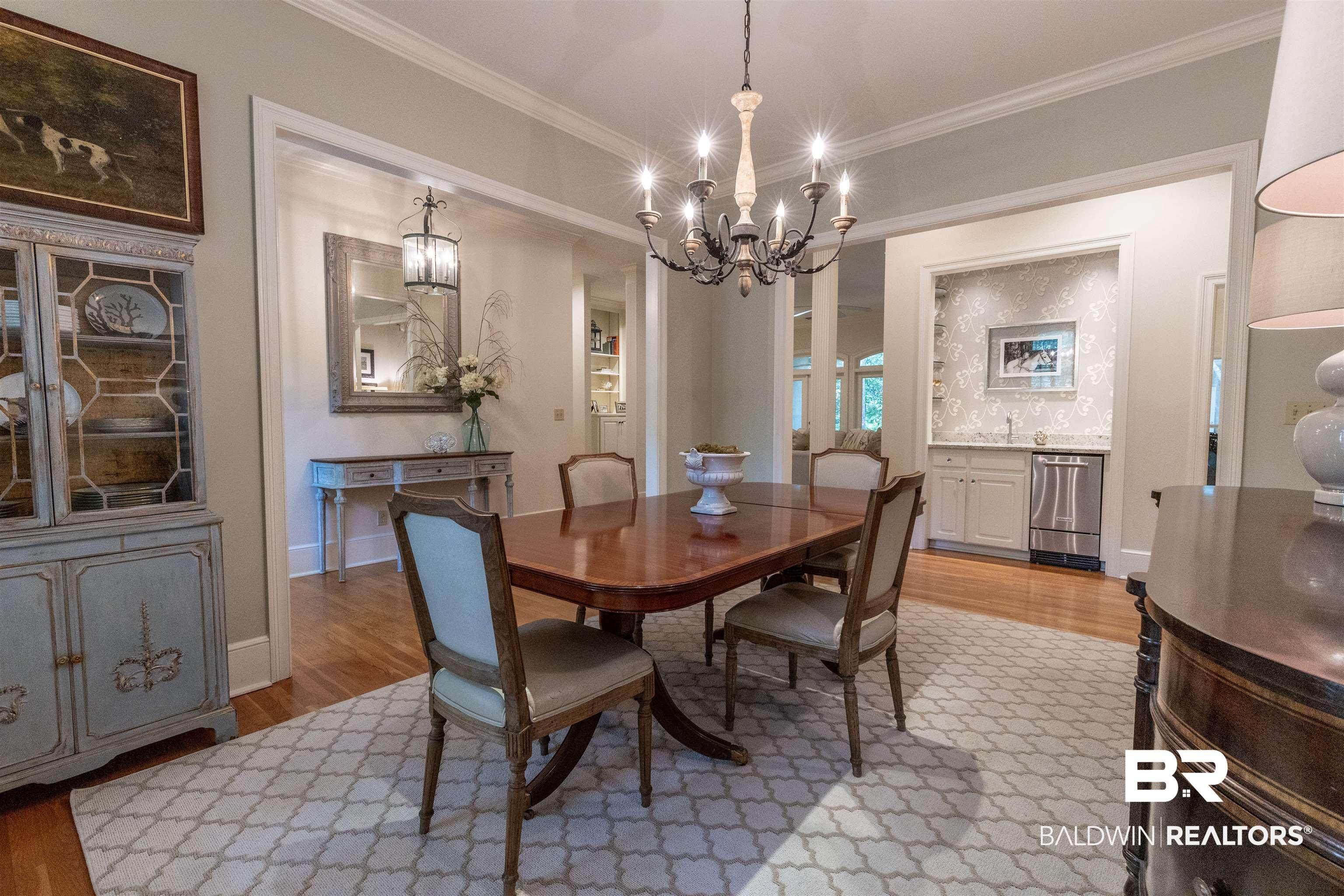 Image 4: Dining room featuring light wood-style flooring, ornamental molding, and suspended lighting