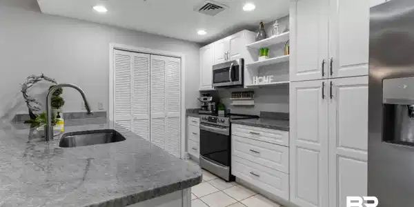 Image 2: Kitchen featuring white cabinetry, granite countertops, stainless steel appliances, and recessed lighting