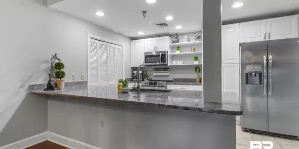 Image 3: Kitchen featuring a breakfast bar with granite countertops, stainless steel appliances, white cabinetry, and recessed lighting