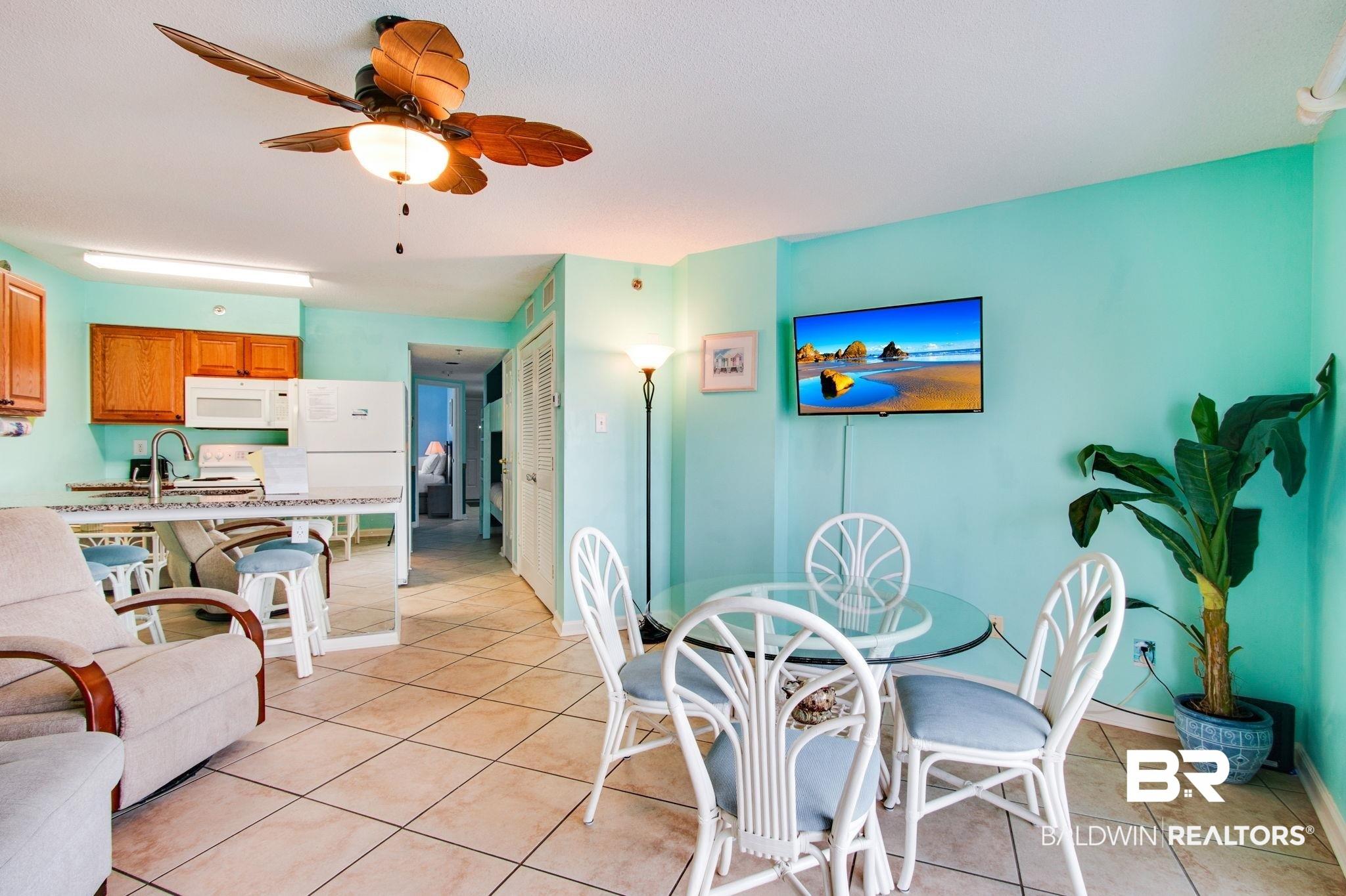 Image 4: Dining area featuring light tile patterned floors and a ceiling fan