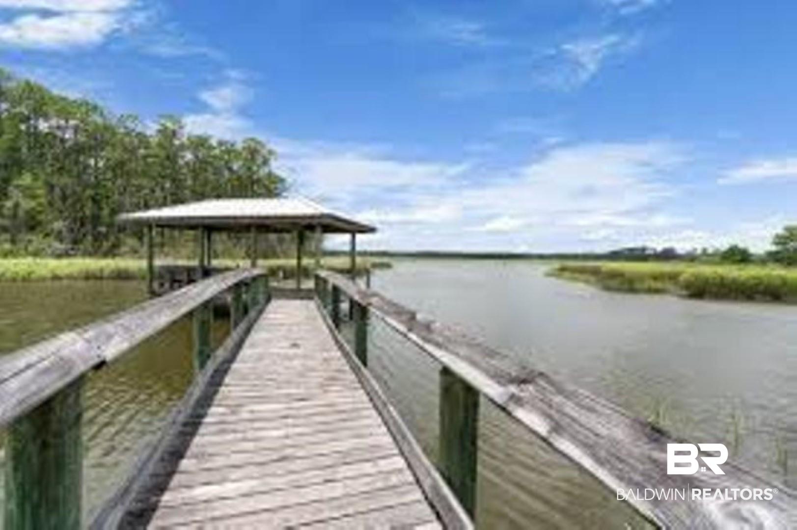 Image 3: Wood-plank dock extending over water, featuring a covered area for fishing with a metal roof