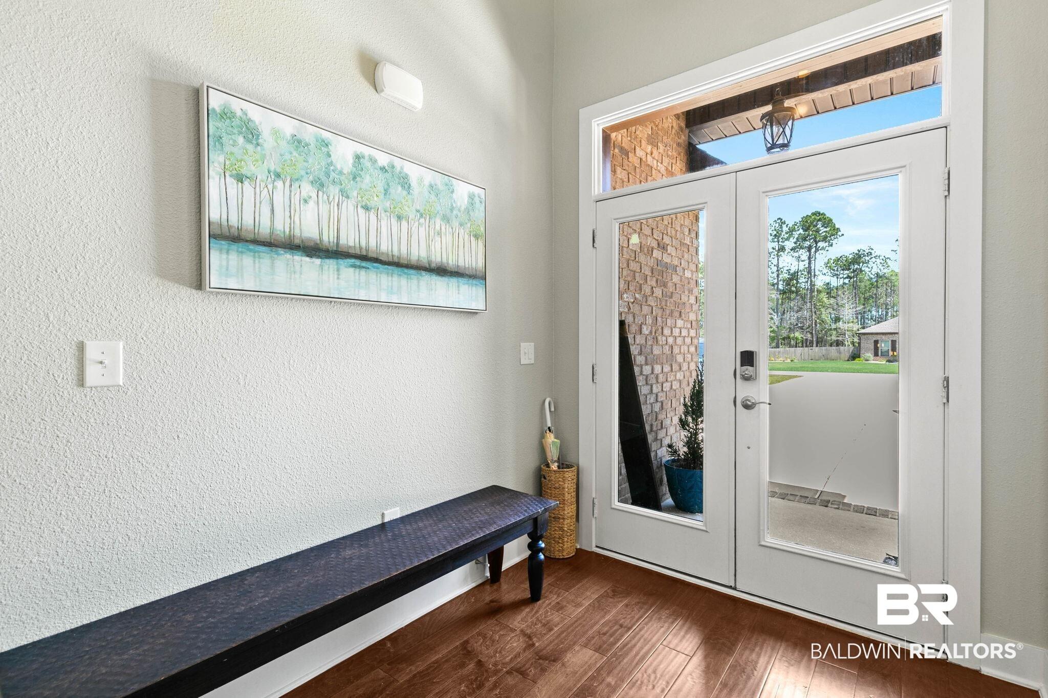 Image 4: Entryway featuring french doors, a textured wall, and dark wood finished floors
