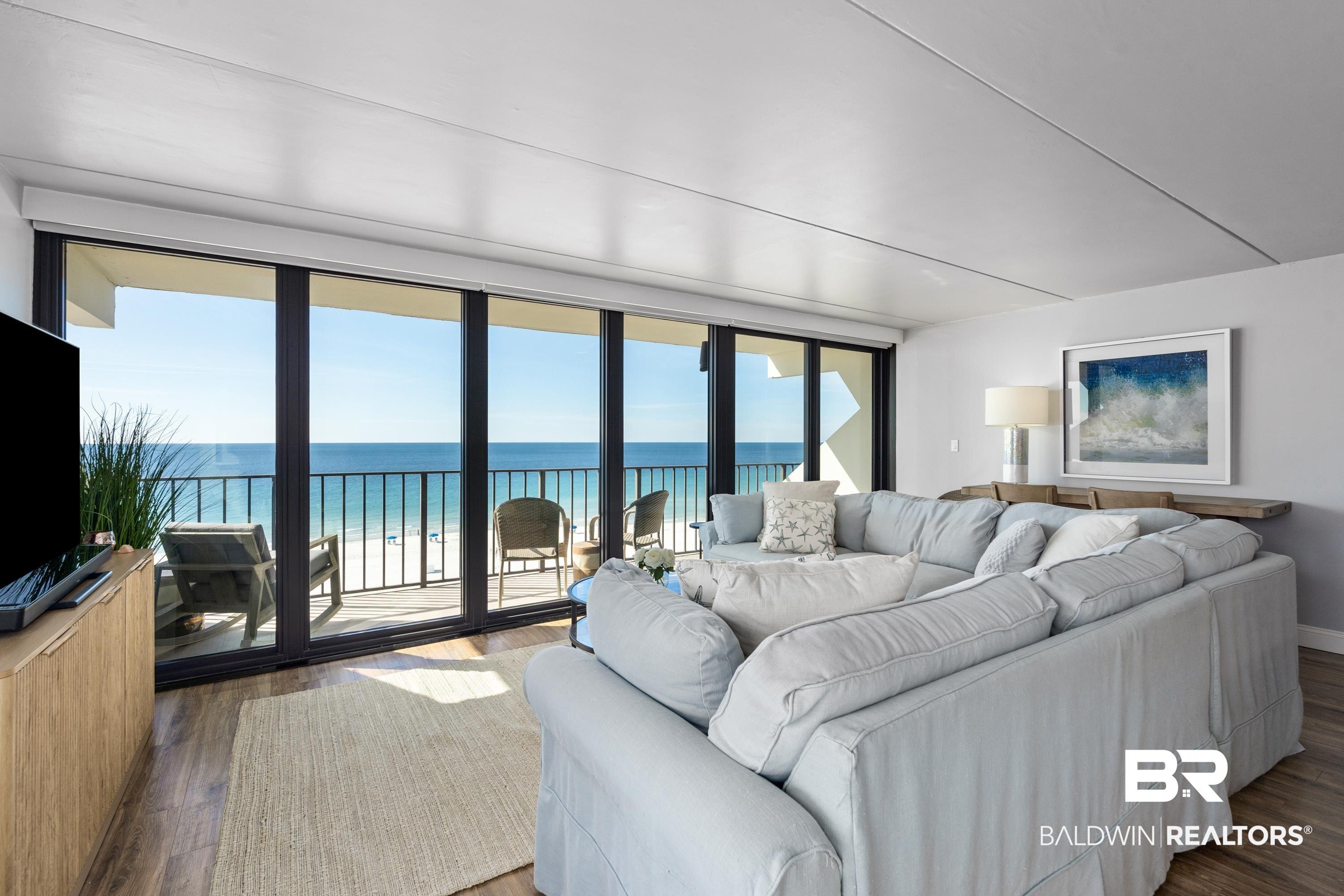 Image 3: Living room featuring a water view, wood finished floors, and expansive windows