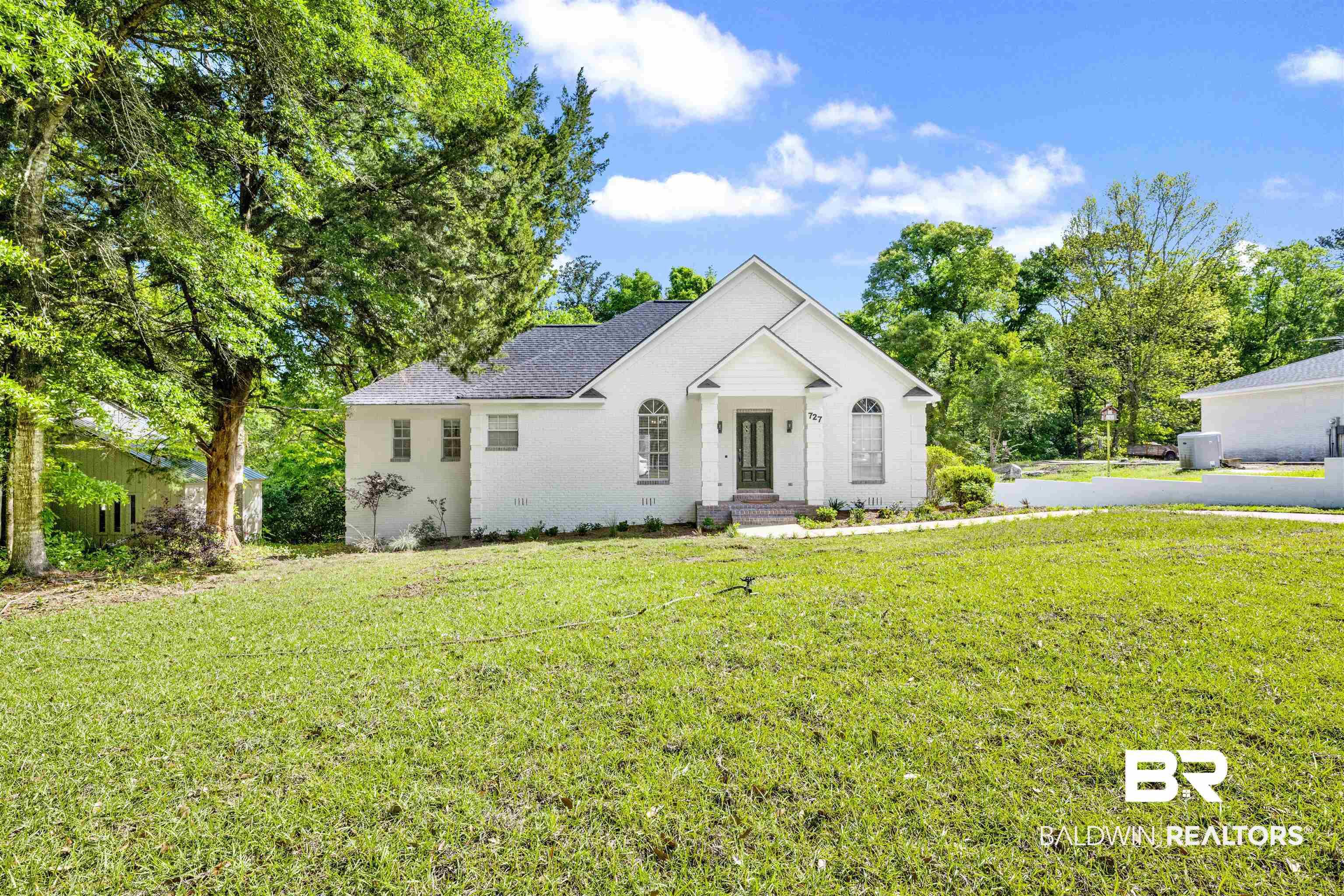 Image 2: View of front facade featuring a front lawn and roof with shingles
