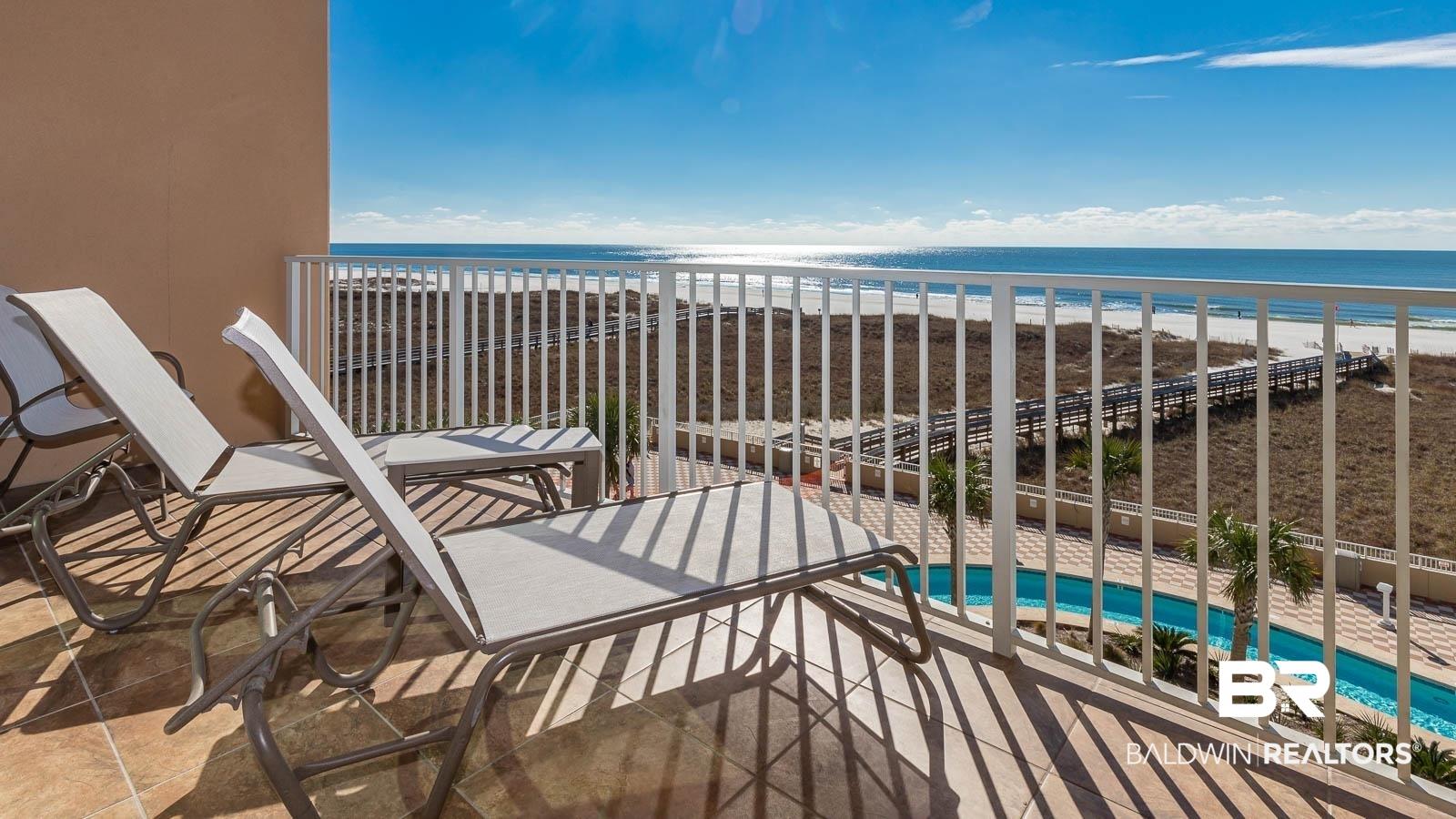 Image 2: Balcony featuring view of pool area and view of water and beach