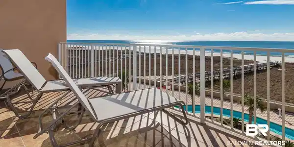 Image 2: Balcony featuring view of pool area and view of water and beach