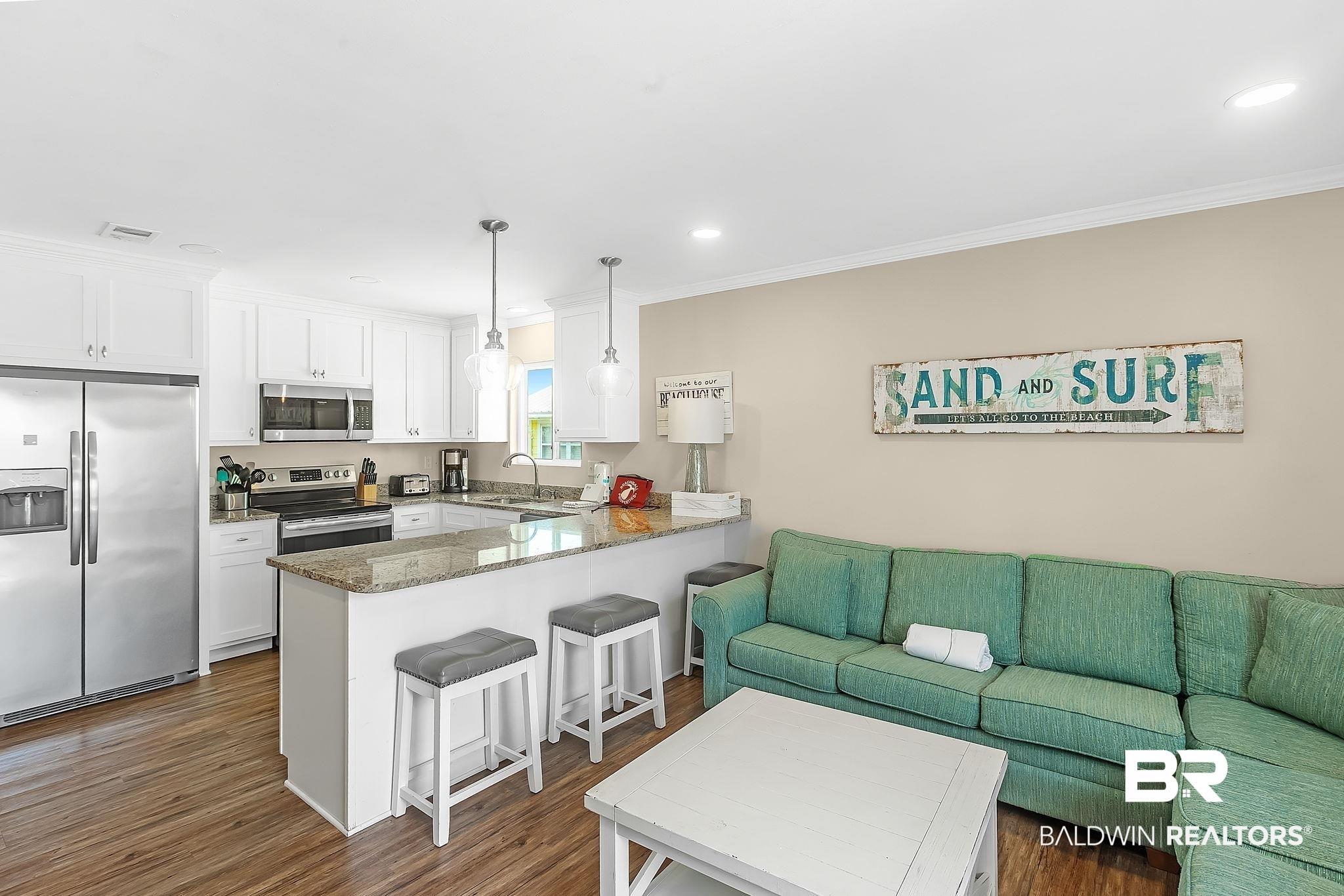 Image 4: Open-concept living area with wood-finish flooring