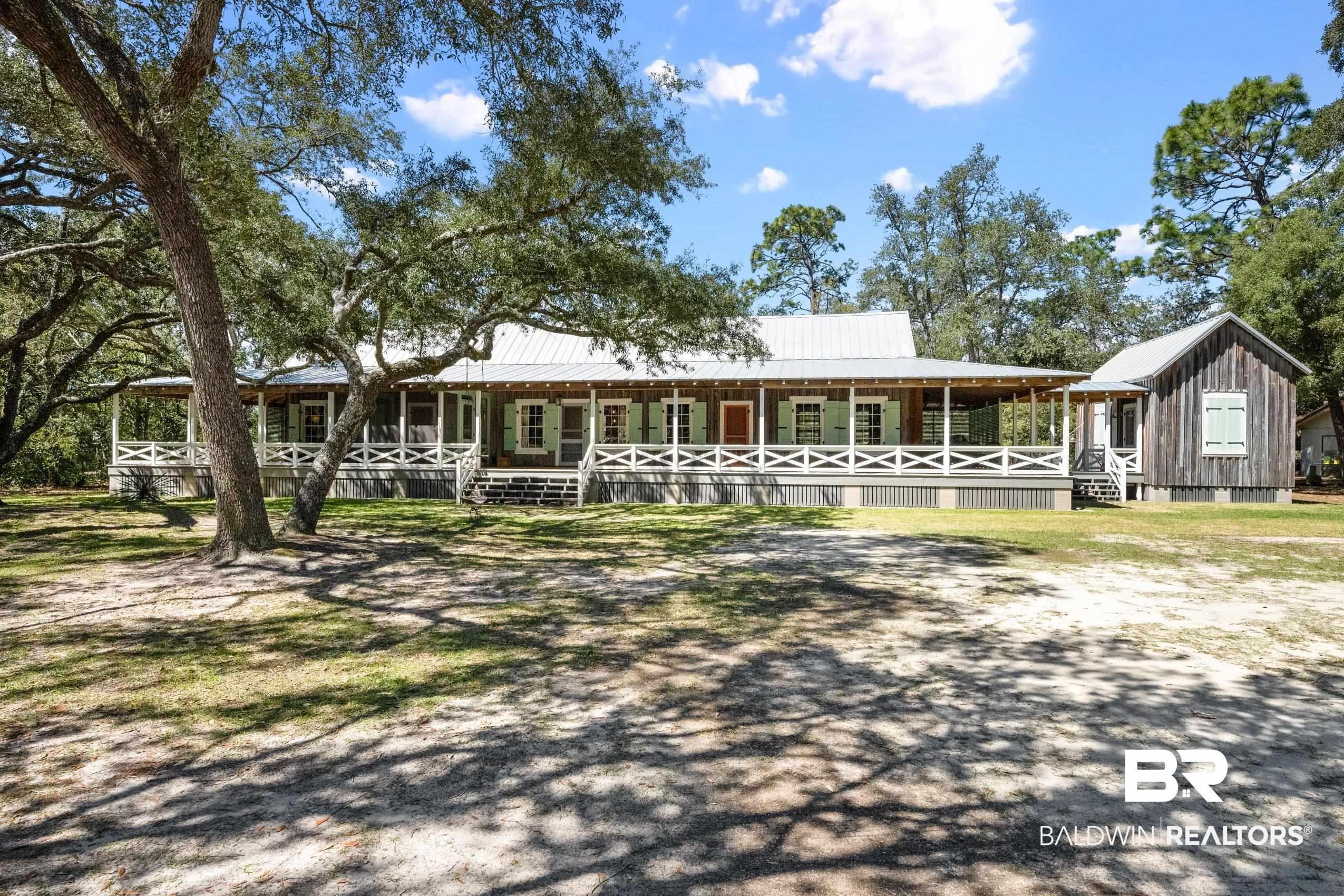 Image 3: View of front of home featuring metal roof, covered porch, and board and batten siding