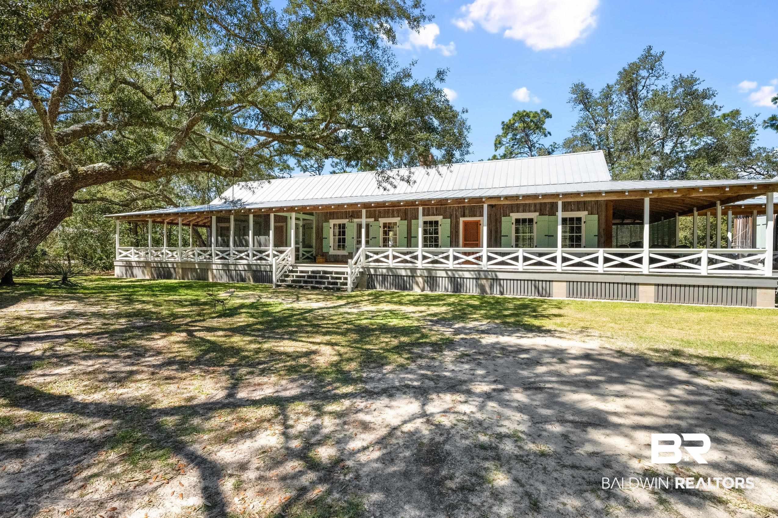 Image 4: Farmhouse inspired home featuring an exterior structure, metal roof, and an outbuilding