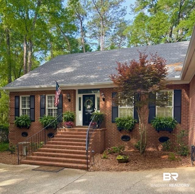 Image 1: View of front of house with brick siding and roof with shingles