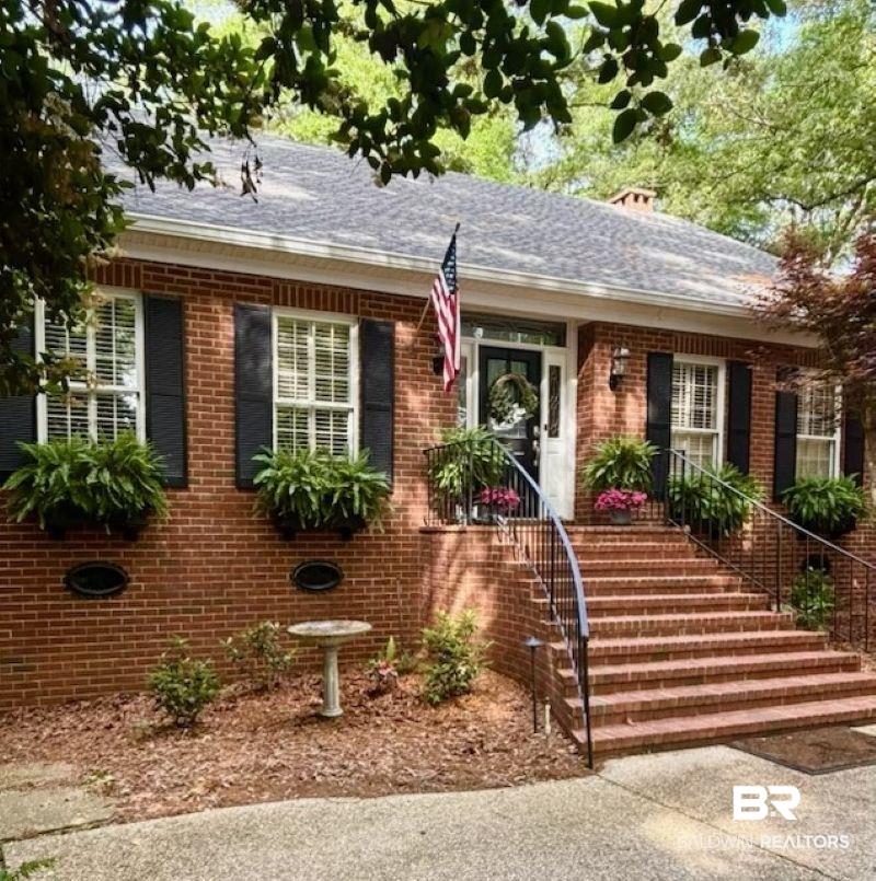 Image 2: View of front of home featuring a porch, brick siding, and a shingled roof