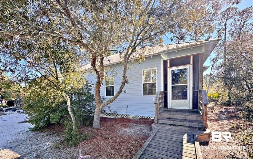 Image 1: Light blue siding exterior featuring a covered entry porch with wood decking