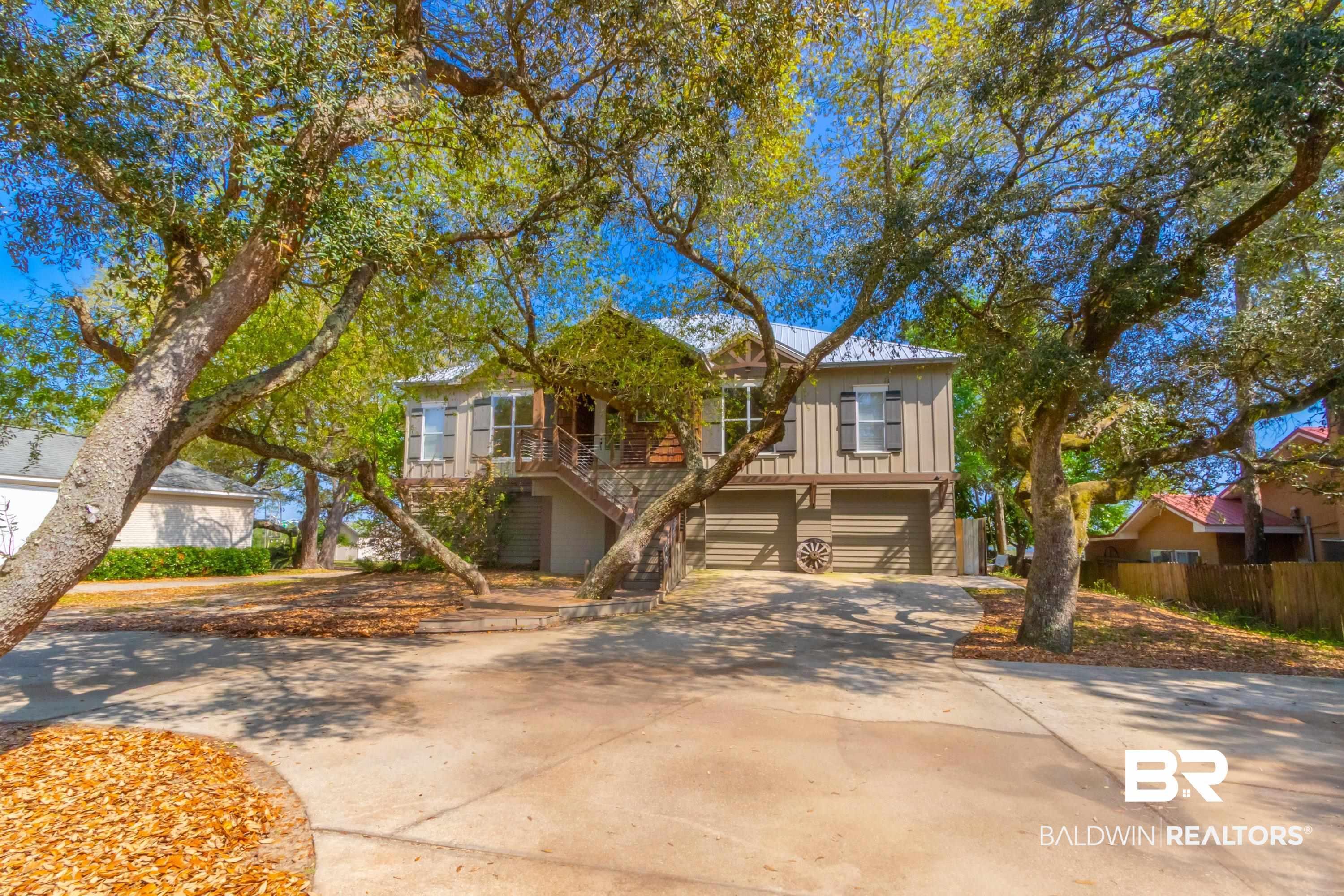 Image 3: Curb appeal enhanced by mature trees and a concrete driveway