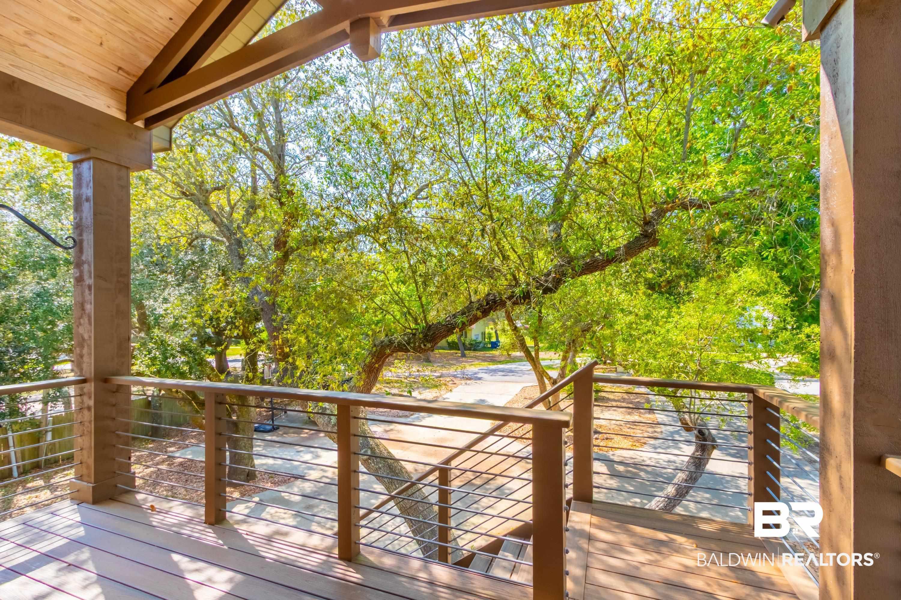 Image 4: Covered exterior deck featuring wood-finish decking and cable railing