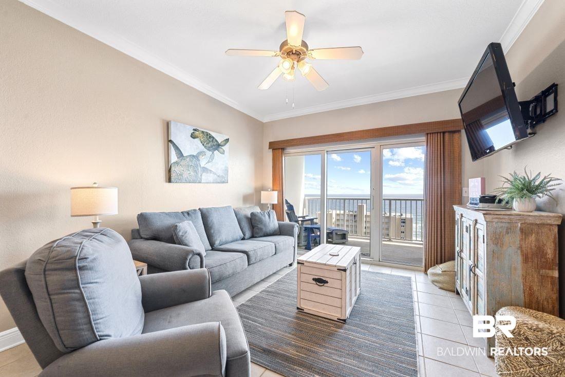 Image 2: Living area with ornamental molding, a ceiling fan, and light tile patterned floors