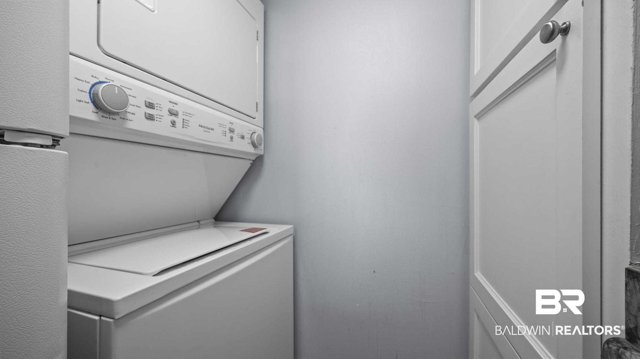 Image 4: Laundry area featuring stacked washer and dryer
