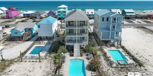 Image 3: Three-story coastal residence featuring multiple balconies and a private pool