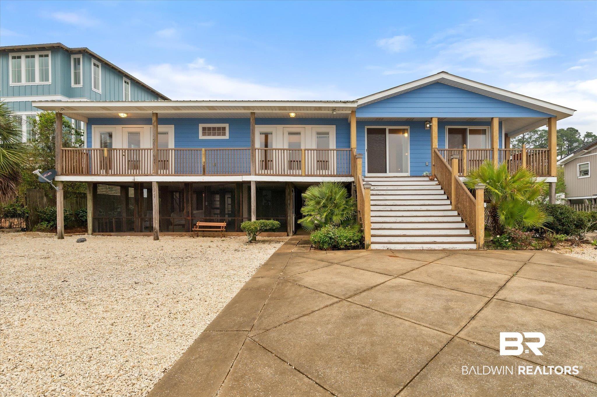 Image 1: Beach home featuring french doors, a porch, and stairs. A rare 100 foot lot.