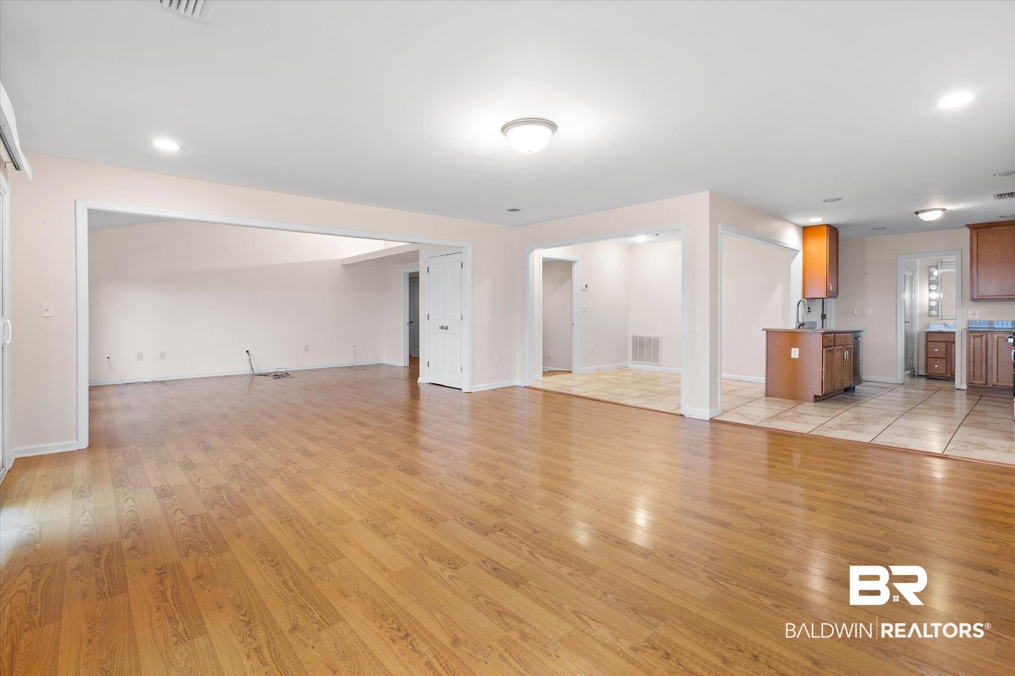 Image 3: Unfurnished living room with a sink, baseboards, light wood finished floors, and visible vents
