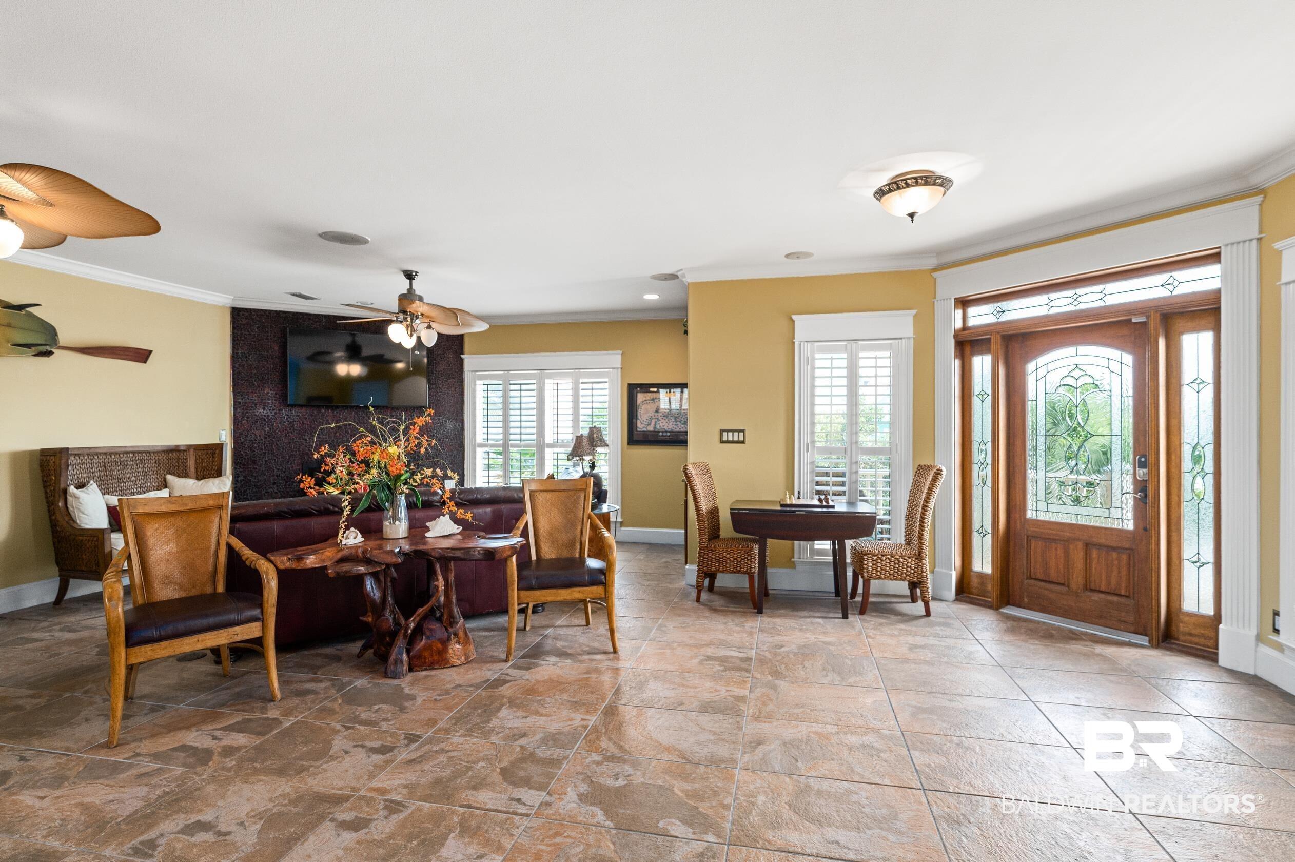 Image 2: Dining area featuring crown molding and light stone finish flooring