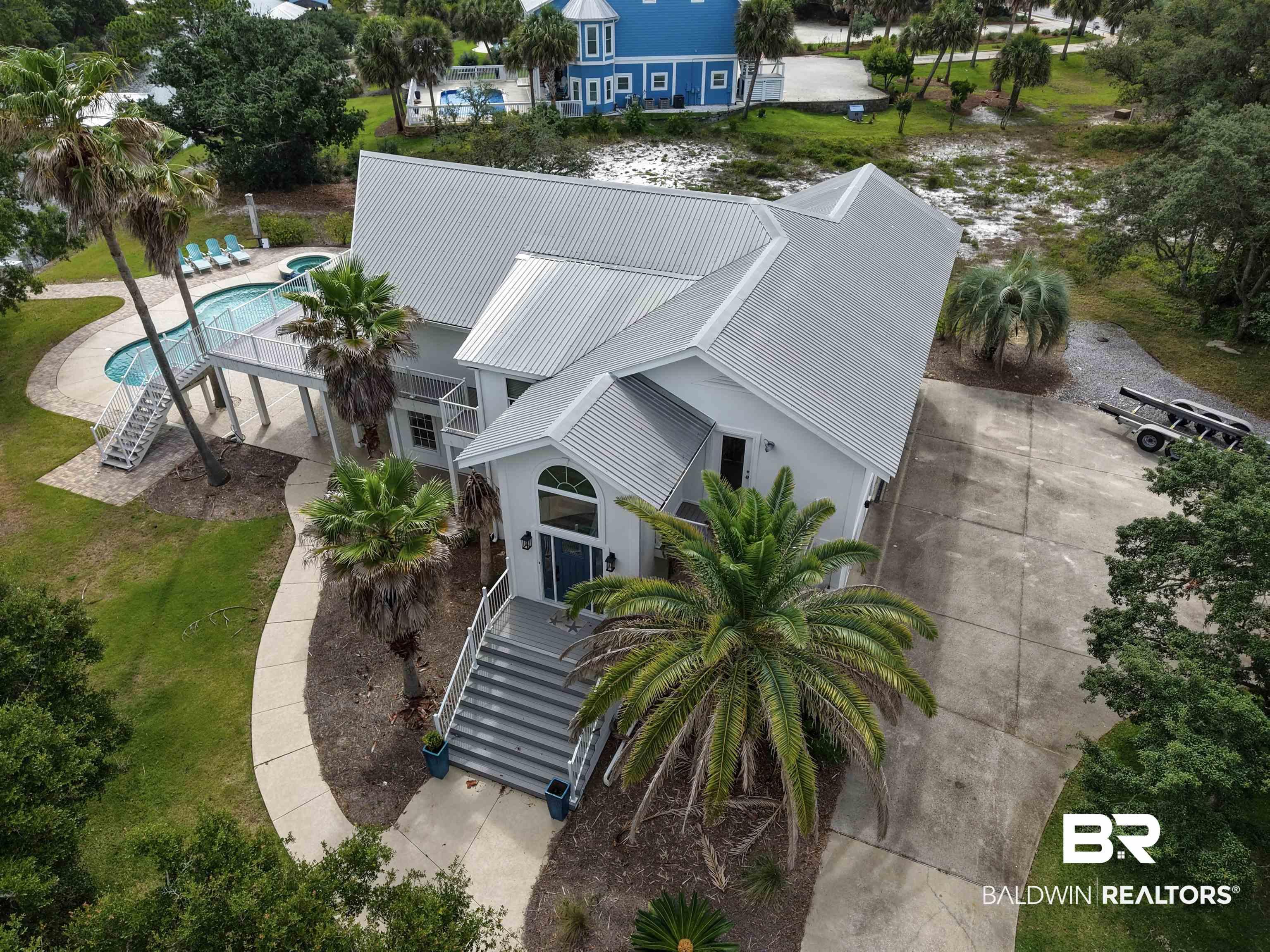Image 1: Property exterior featuring a light-colored facade and a metal roof