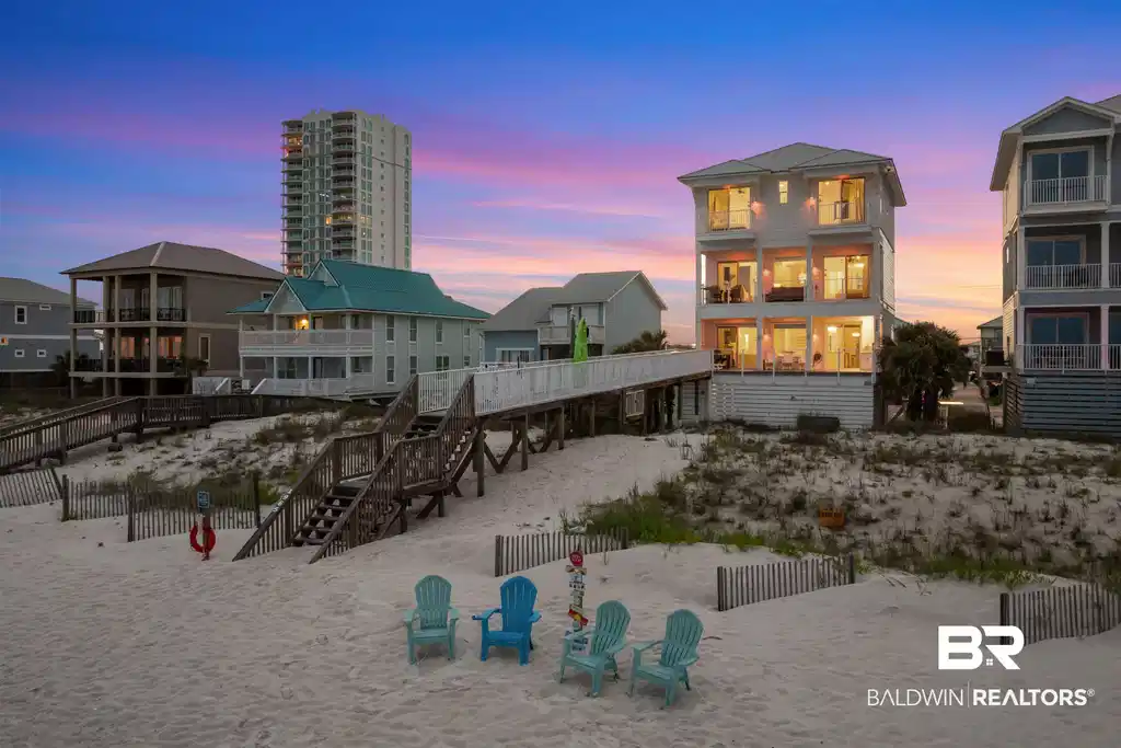 Image 1: Three-story coastal residence featuring multiple balconies and abundant exterior lighting