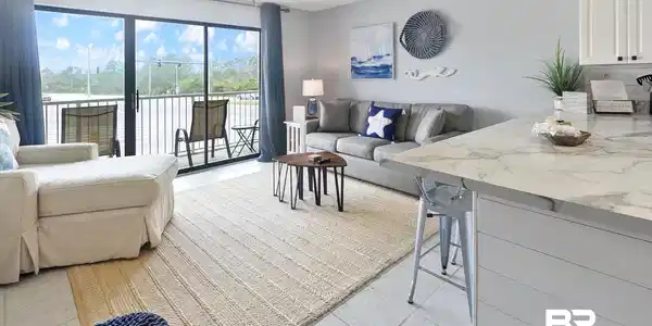 Image 2: Open concept living area featuring a spacious balcony, tile flooring, and a ceiling fan