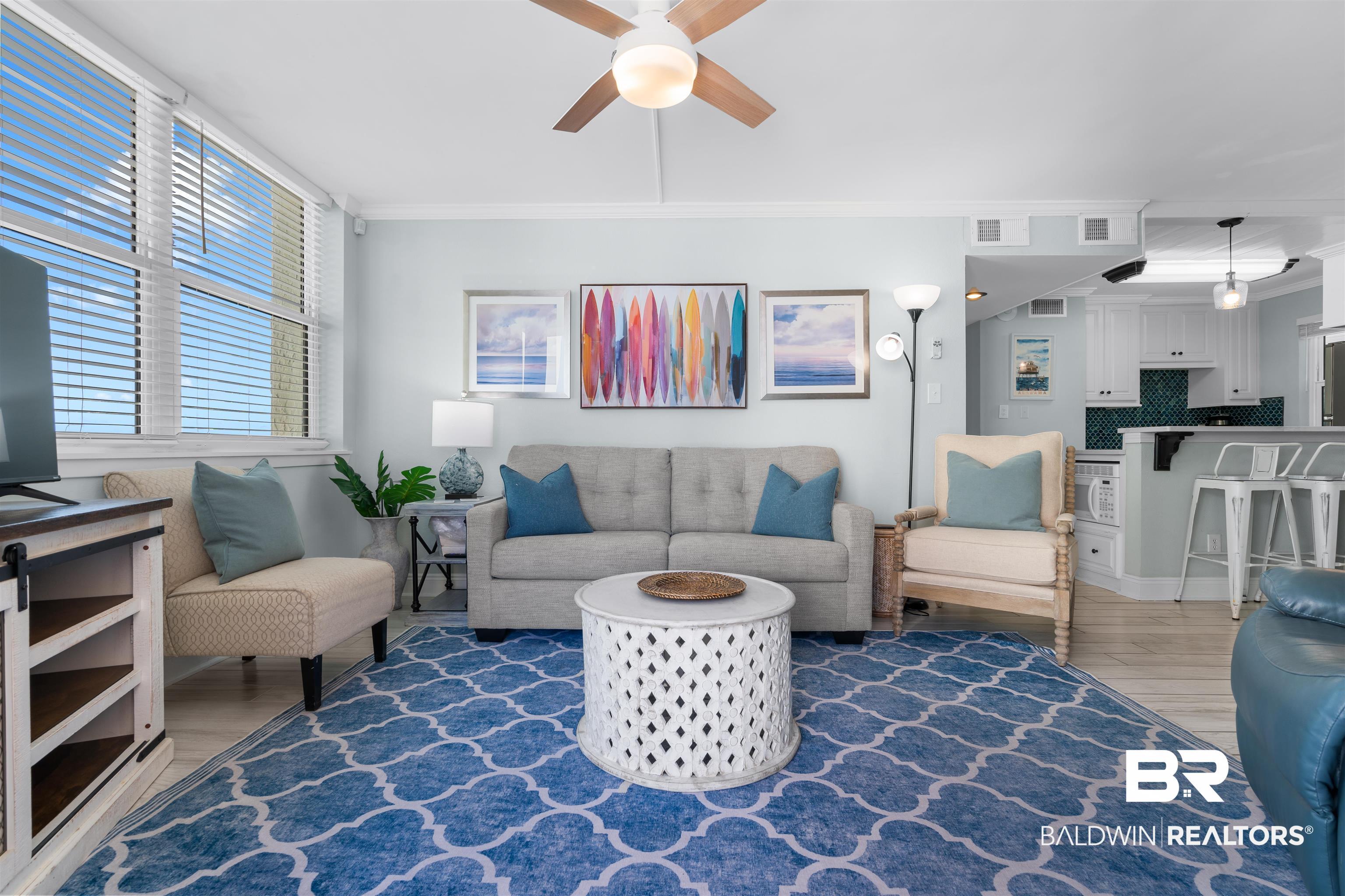 Image 4: Living area featuring light wood-style floors, a ceiling fan, and crown molding