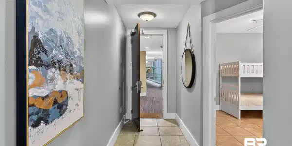 Image 3: Hallway featuring light tile patterned floors and baseboards