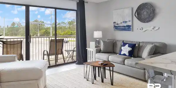 Image 3: Living area featuring sliding glass doors opening to a balcony