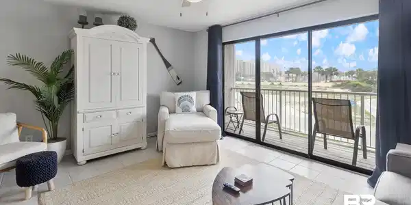 Image 4: Full-height glass doors open to an outdoor balcony with metal railing
