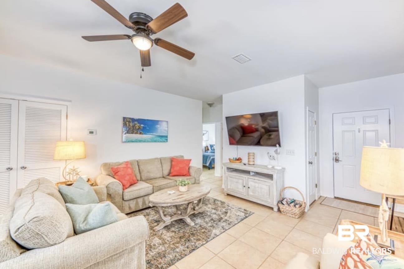 Image 4: Living area featuring ceiling fan and light tile patterned flooring