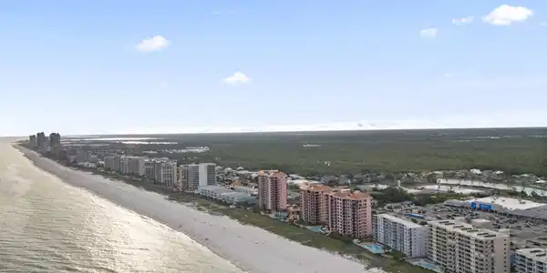 Image 3: Birds eye view of property with a water view and a beach view