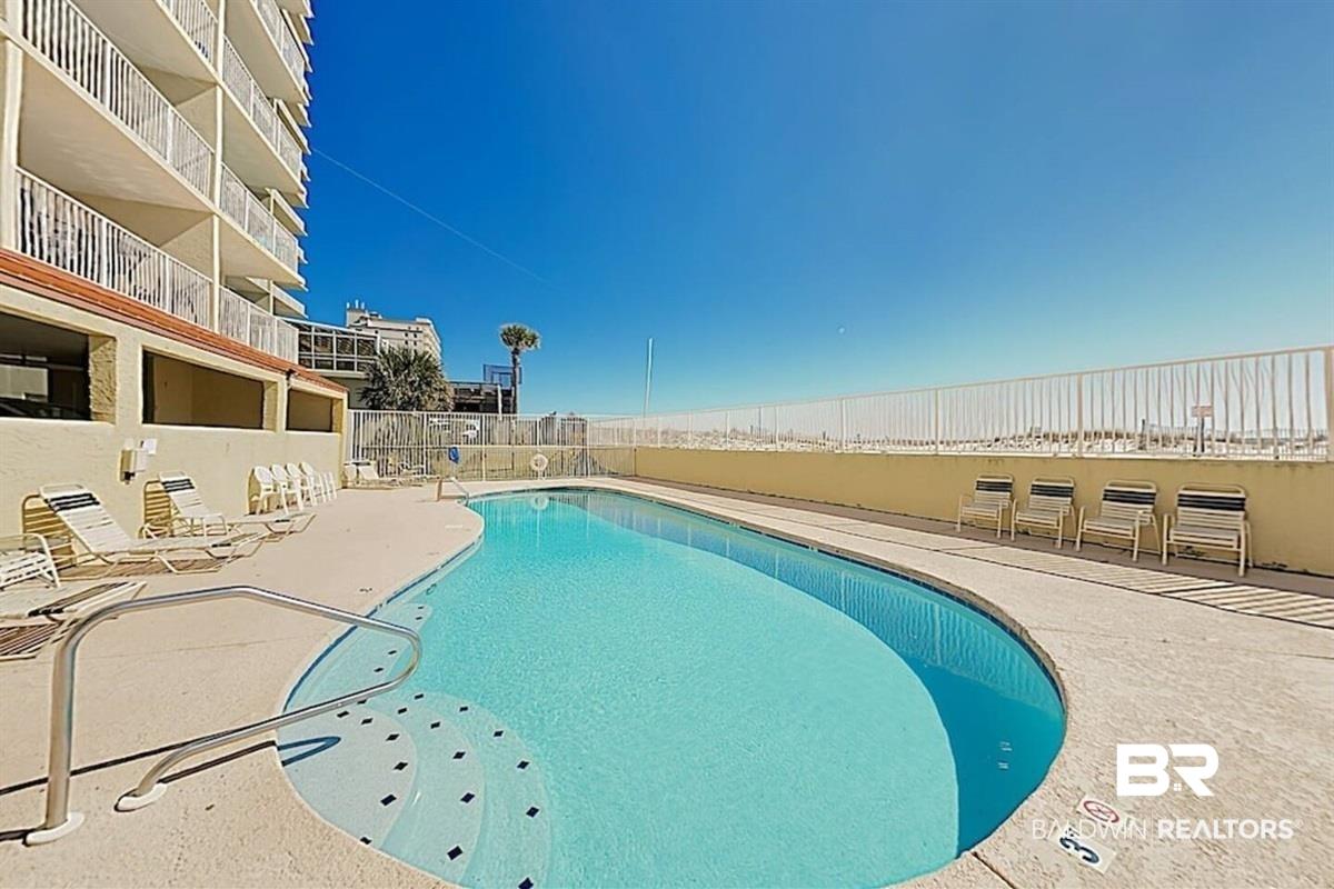 Image 3: Community pool featuring a patio area