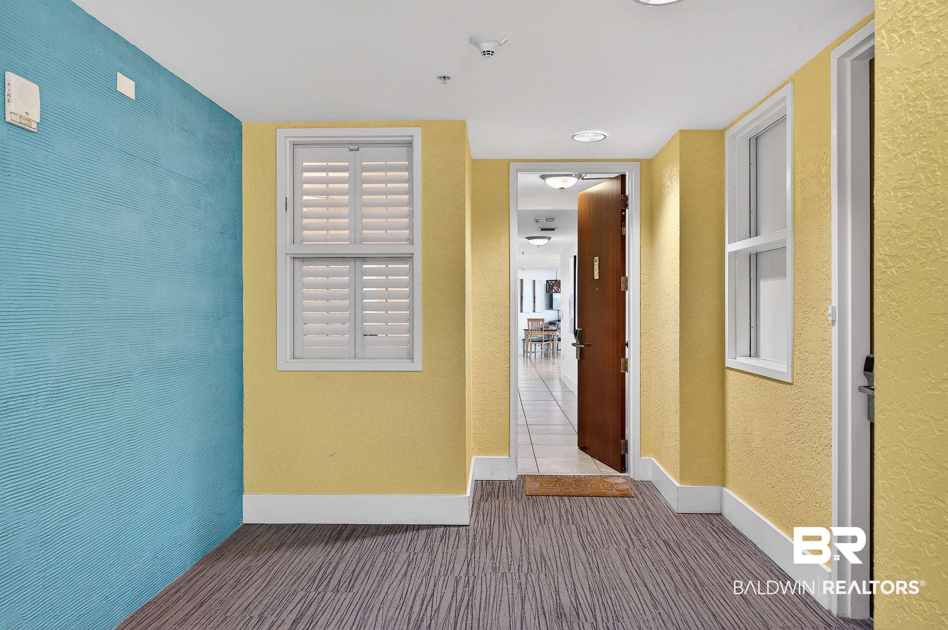 Image 2: Corridor with baseboards and a textured wall