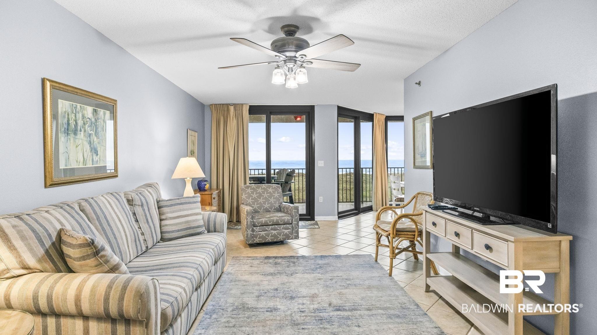 Image 4: Living area with light blue walls, tile flooring, and a ceiling fan