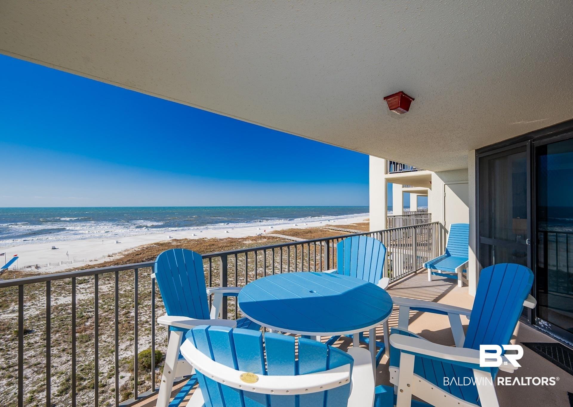 Image 1: Balcony with view of water and beach and outdoor dining area