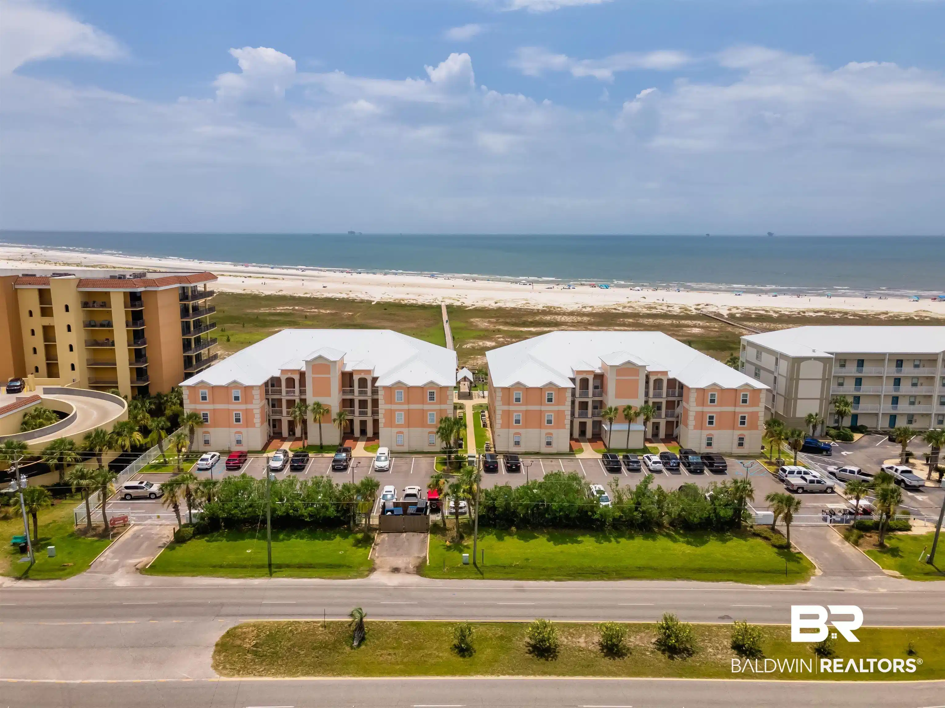 Image 1: Bird's eye view of unending shoreline and apartment complex