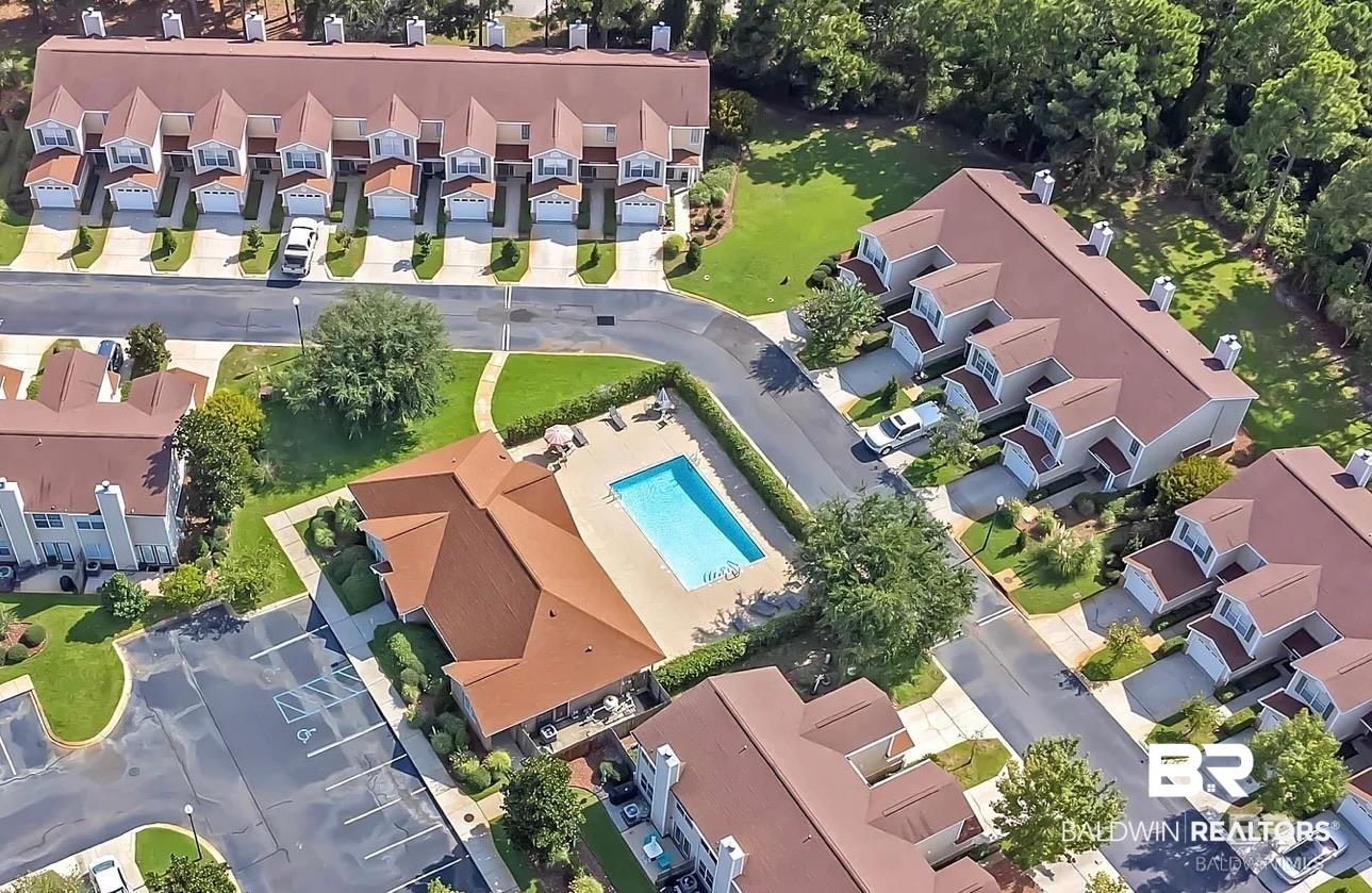 Image 3: Community swimming pool with surrounding patio, clubhouse building, and multiple residential structures featuring attached garages