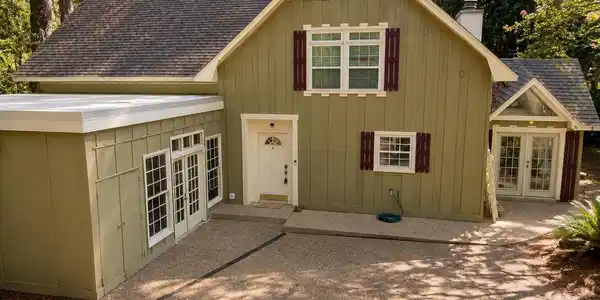 Image 4: Exterior featuring horizontal siding, a gravel driveway, and a prominent front entry with a half-moon window