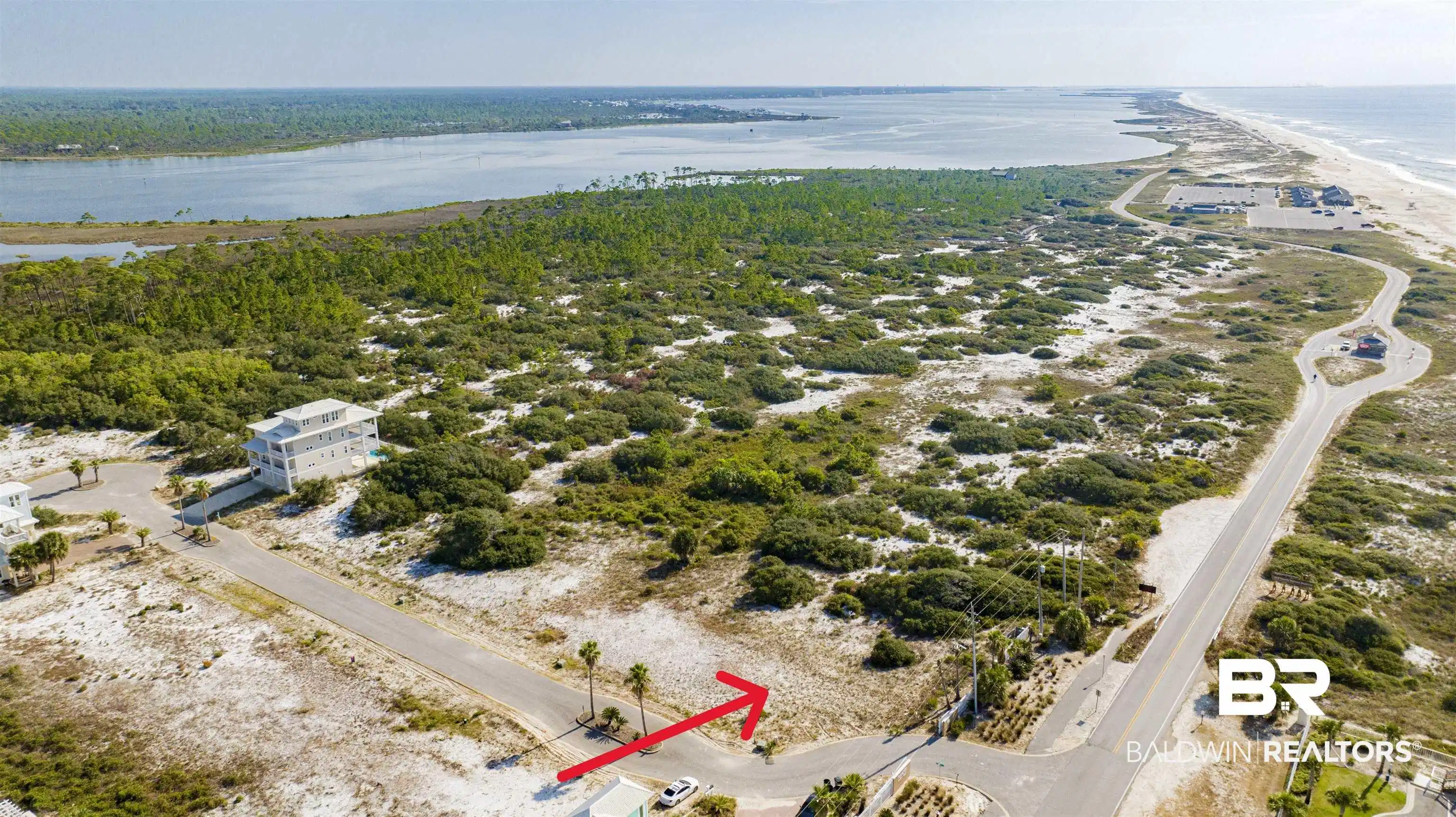 Image 1: Bird's eye view of waterfront with a beach