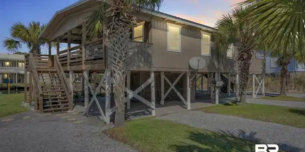 Image 3: Elevated coastal-style residence featuring a spacious covered deck and exposed pilings