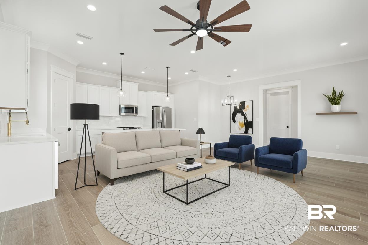 Image 3: Open-concept living space featuring wood-finish flooring, recessed lighting, and crown molding