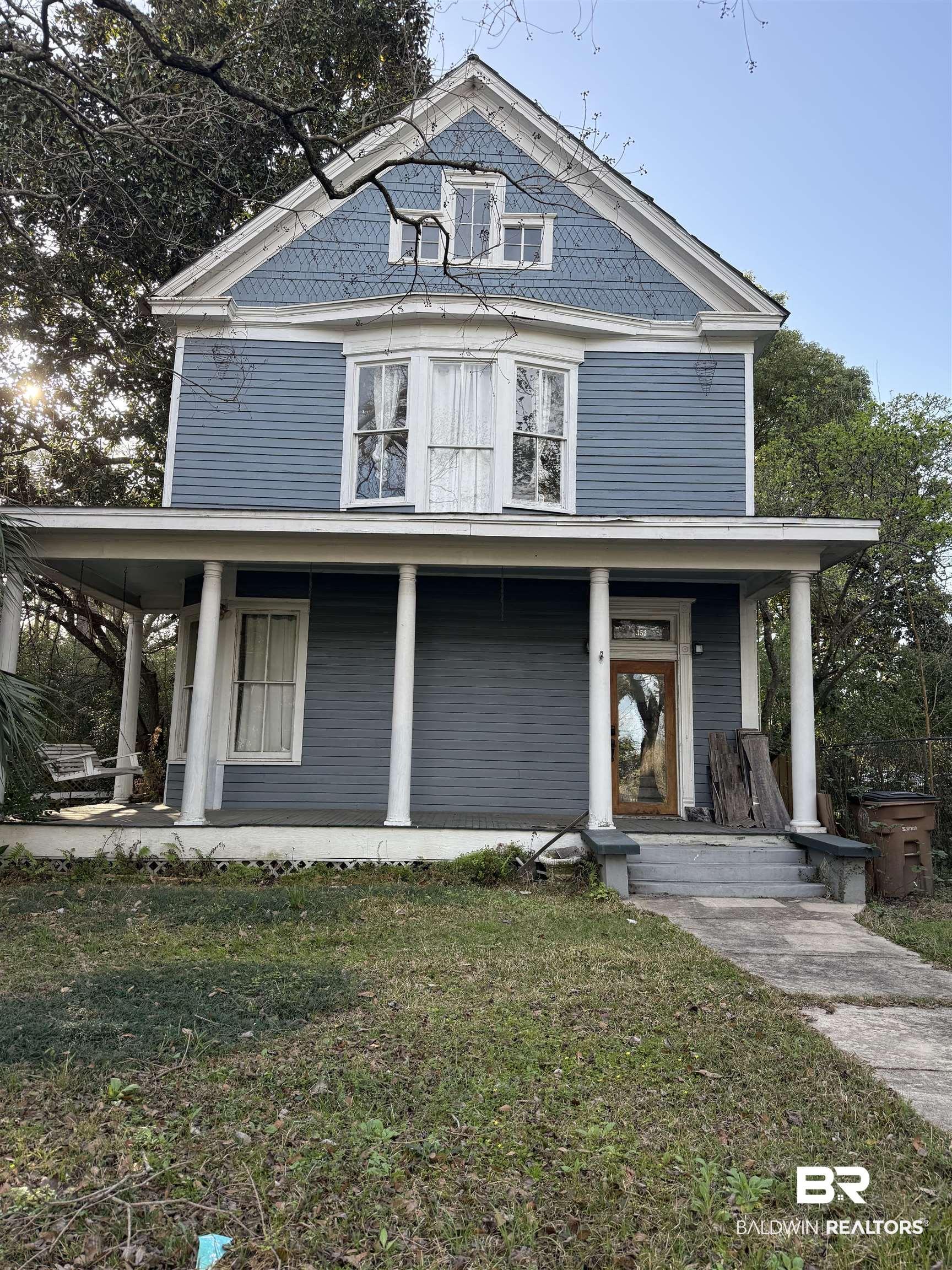 Image 1: View of front of home with a front yard and a porch
