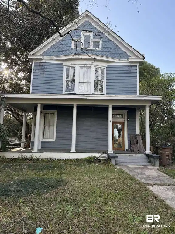 Image 1: View of front of home with a front yard and a porch