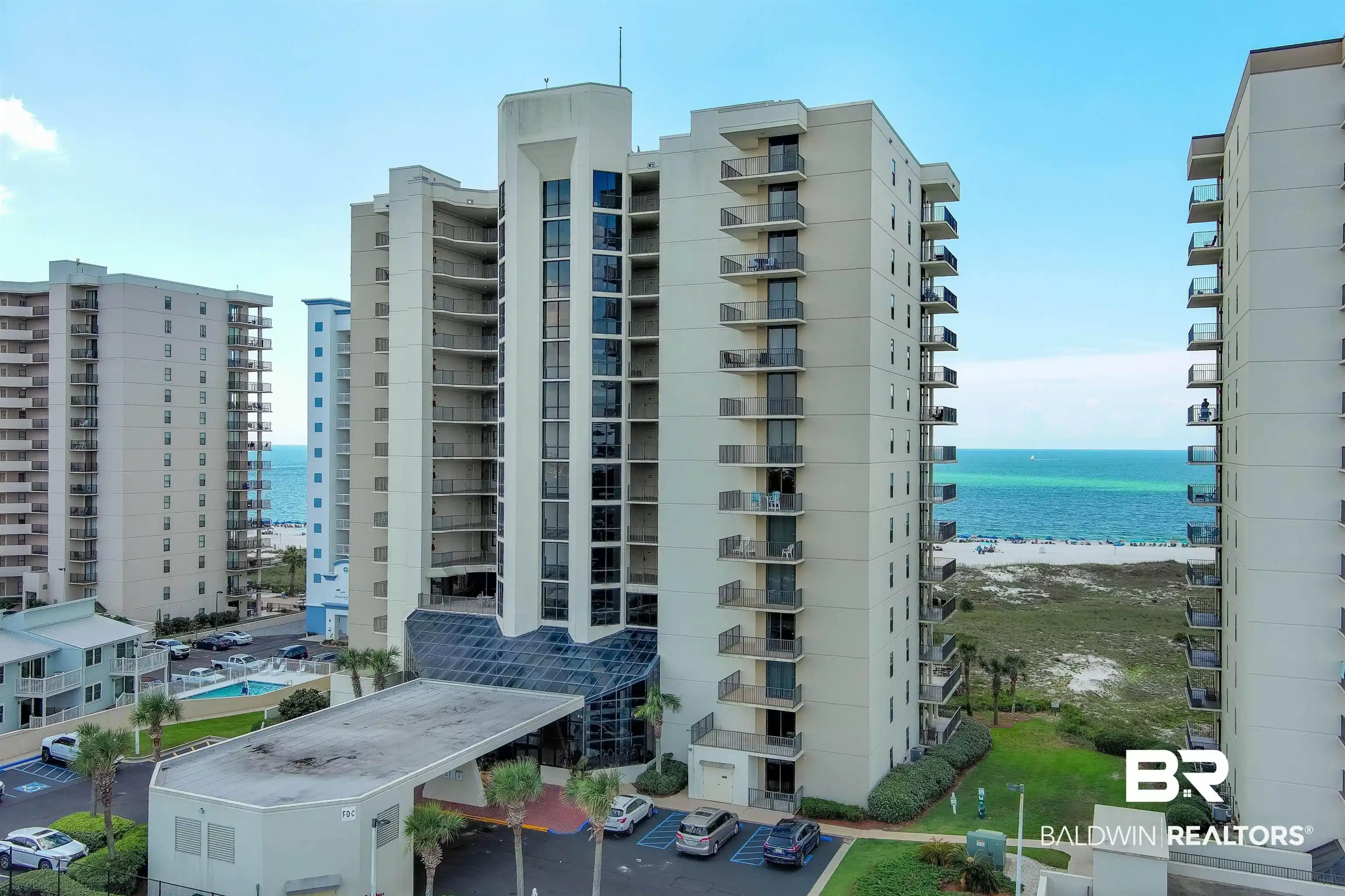 Image 1: High-rise condominium building featuring multiple private balconies, a ground-level covered entry, and dedicated parking
