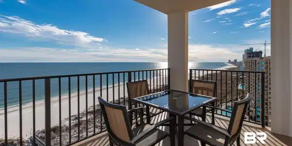 Image 3: Spacious balcony featuring direct oceanfront exposure, a white sand beach, and a black metal railing