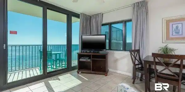 Image 3: Sliding glass doors opening to a balcony with metal railings and expansive water views